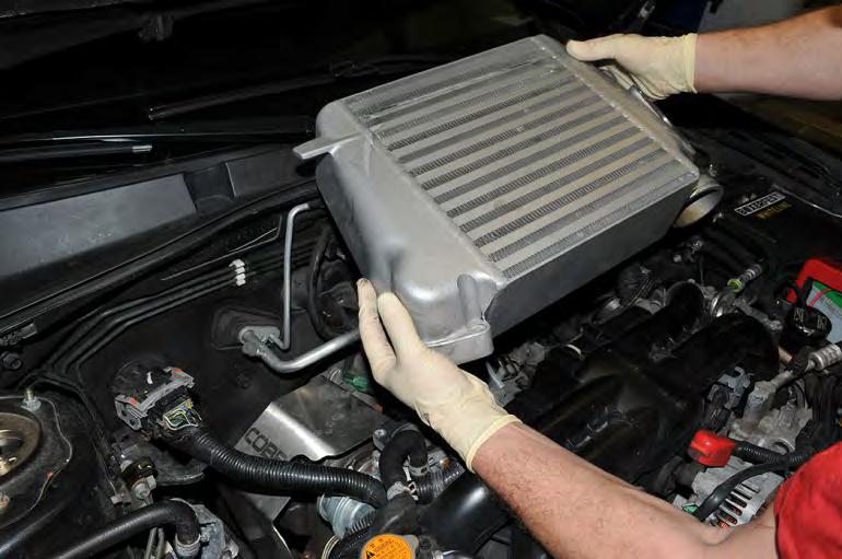 6. Grab the intercooler by the sides and carefully wiggle it out of