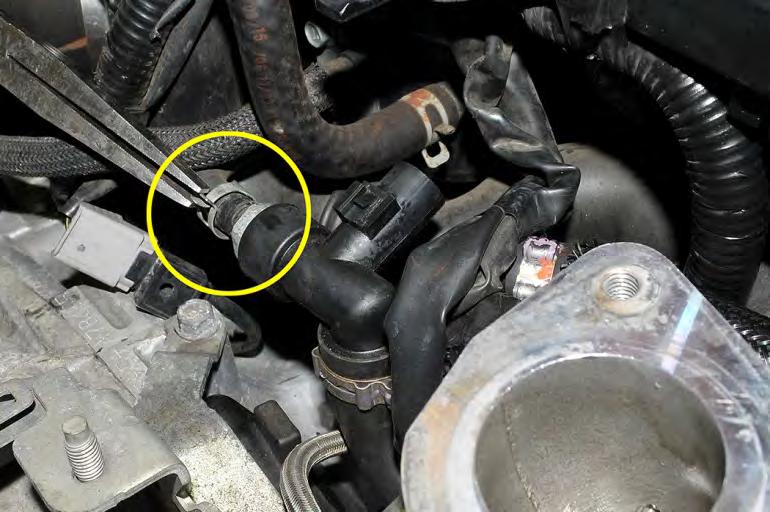 12. Remove the small pinch clamp that holds the hose to the PCV valve using pliers.