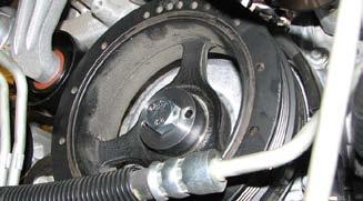 83. Install GM Flywheel Holding Tool #J-42386-A to prevent the crank from rotating while loosening the balancer bolt and