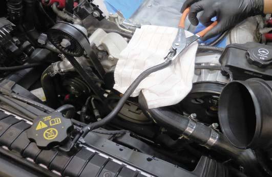 48. Place a rag down as shown to catch any coolant.