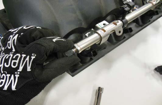 Use a 10 mm socket or nut driver to remove the four throttle body mounting bolts from the OEM