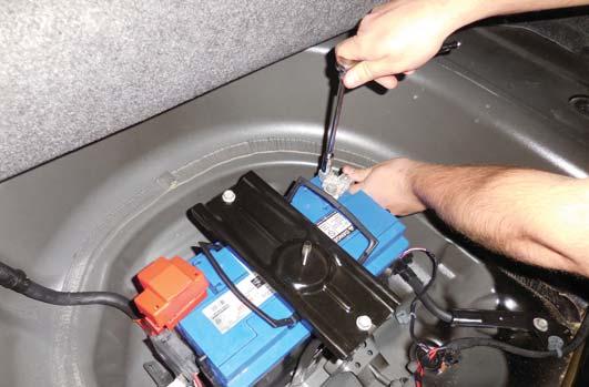 Reconnect the battery negative terminal in the trunk and replace the associated covers reversing the removal steps.