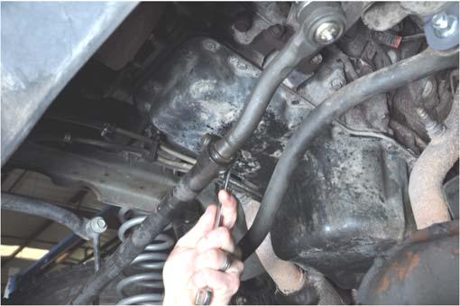 Remove the stock bolt from the clamp closest to the pitman arm using a 15mm wrench.