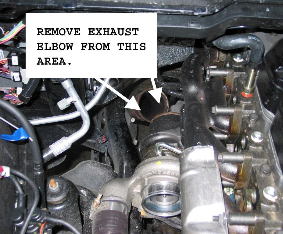 From underneath the vehicle, remove the downpipe-to-turbo elbow band clamp using a 10mm socket.