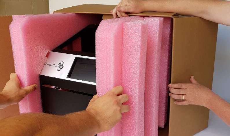 6. Pull on the pink padding to remove the printer and its padding.