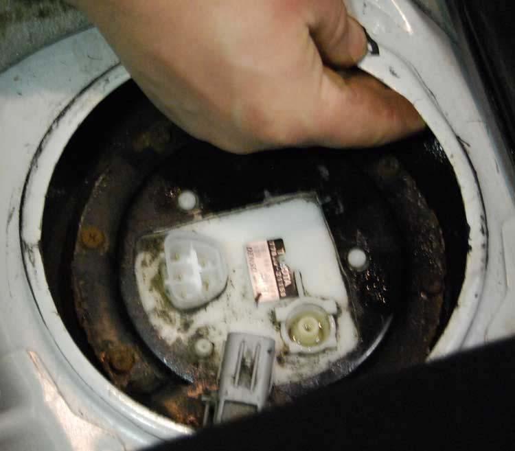 9. Using a ¼ ratchet, extension and 8mm socket remove the bolts retaining the sending unit hold down.