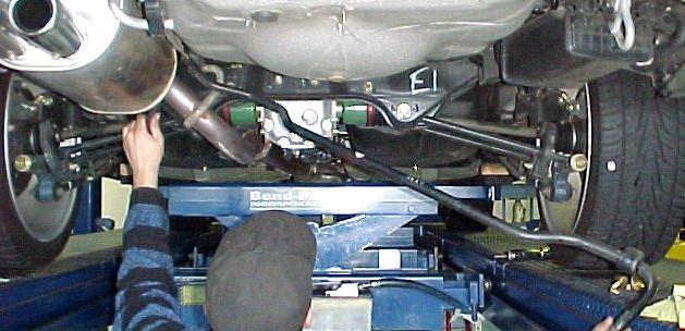 Use a 14mm wrench or socket to loosen and remove the bolts holding the end links to the sway bar. Retain the hardware for later use.