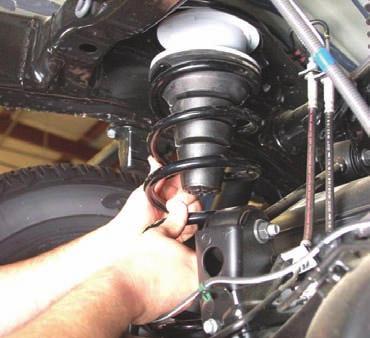 4. Using a 17mm socket or wrench disconnect the bottom of the sway bar links. See PHOTO 2. PHOTO 1 PHOTO 2 Remove lower shock bolt. Remove sway bar link. 5.