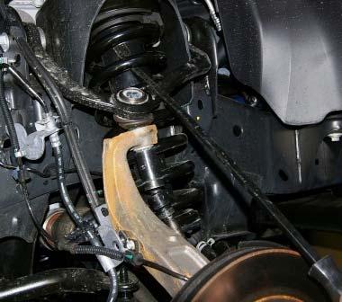 Tighten the three upper strut mounting nuts, reinstall the tie rod end, and tighten the lower