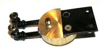 The stub of the tension pin near the rear of the top is hollow which allows the steam to flow into the valve. The pin together with a slot in the disk limits the rotation of the disk.