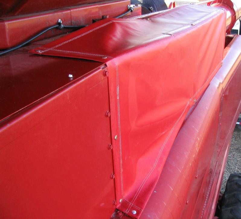 bottom of the brace. Pull the tarp to the front of the combine keeping it straight with the back. The tarp will go over the pivot of the support rod on the auger.