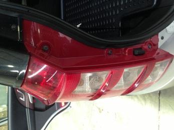Remove black cover above tail light and