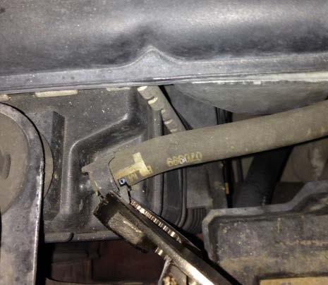 3) Remove the radiator reservoir tank This requires removing a wiring harness, two hoses, and three nuts.