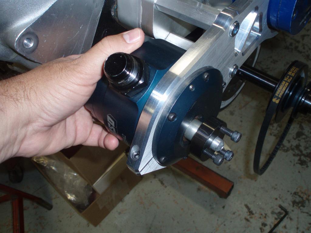 PLACE THE VACUUM PUMP, MINUS PULLEY, THROUGH THE BACK OF THE INSTALLED BRACKET. IT SHOULD FIT WITH A LIGHT PRESS AND ROTATE FREELY WITHOUT THE PINCH-BOLT TIGHTENED.