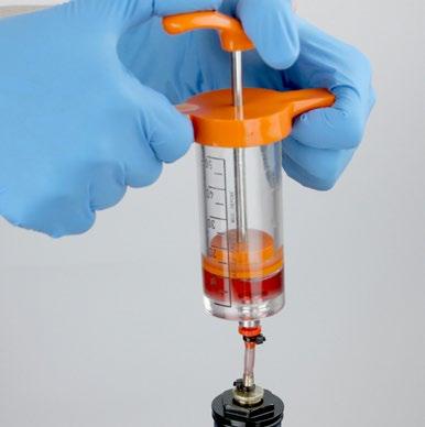 Pressurize the damper assembly by pushing down on the syringe handle and simultaneously pulling down on the rebound