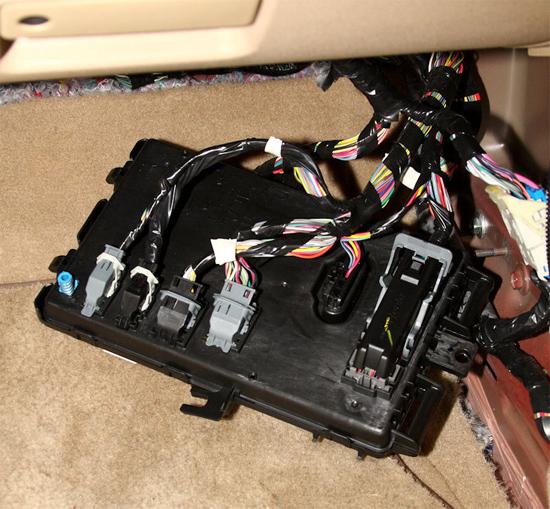 Pull the lower end of the Smart Junction Box towards the center of the car, and then once it s free pull the whole box down.