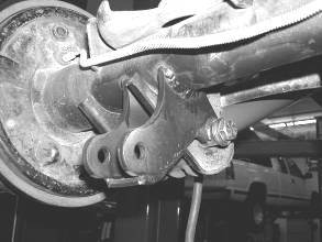Locate the emergency brake cable bracket mounted to the body above the differential. Remove and allow to hang freely, save the factory hardware. 44. Locate the shock mount on the axle.