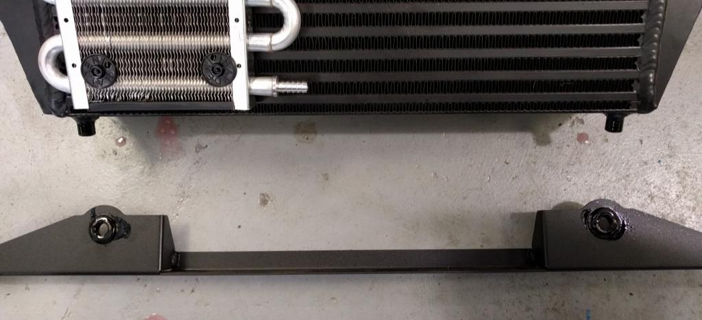 Use some lubricant to help slide the lower mount over the 2 posts on the intercooler. 2. Using a 16mm socket remove the two bolts on the front of the bottom frame tubes.