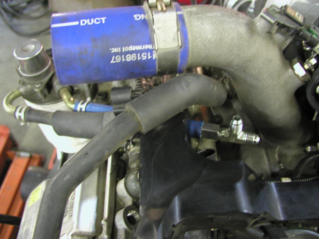 16. Route supplied ½ fuel hose from fuel filter housing to the supplied -6 tee using the