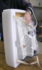 Lift the instrument out of the transport carton by the carrying straps (5) and place it
