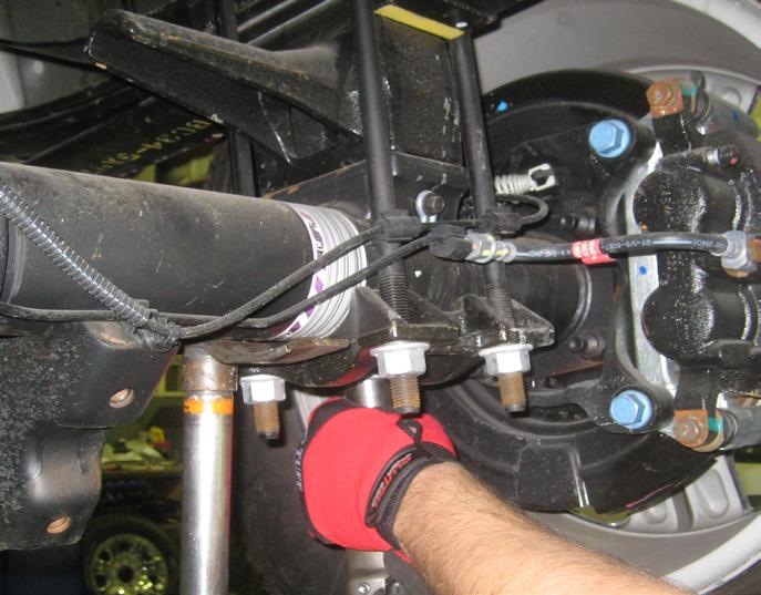 working on the driver side, install the new block between the bottom of the leaf spring pack and the axle perch.