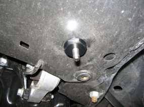 Locate the (2) 1 holes in located in the floor pan at near the back of the transmission.