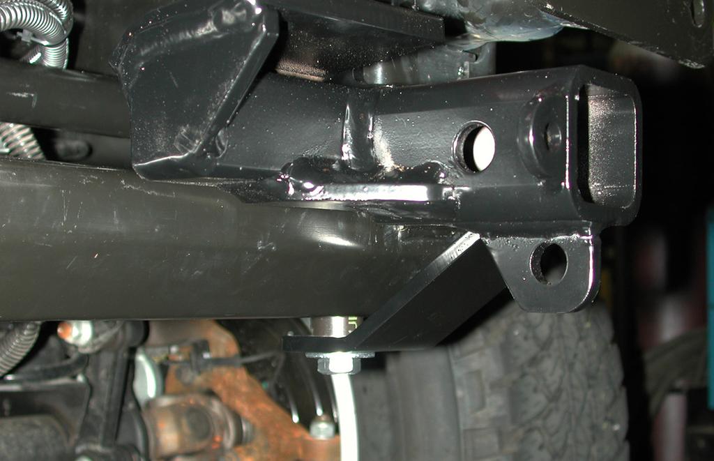 Using the lower mounting point of the main receiver brace as a template, drill a ½" hole through the frame support on the