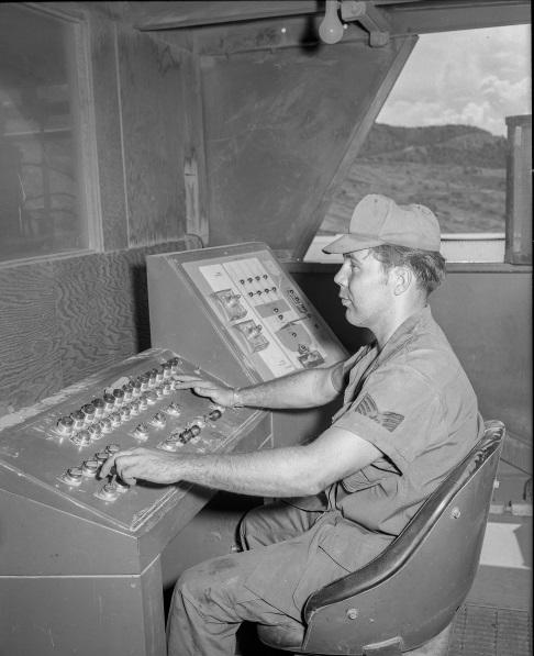 A operator sat at a control board watching a scale of mix being made, making sure that it was the right