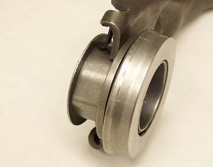 The tips of the clutch fork and the spring fingers on the rear side of the clutch fork both fit inside the same groove on the release bearing.