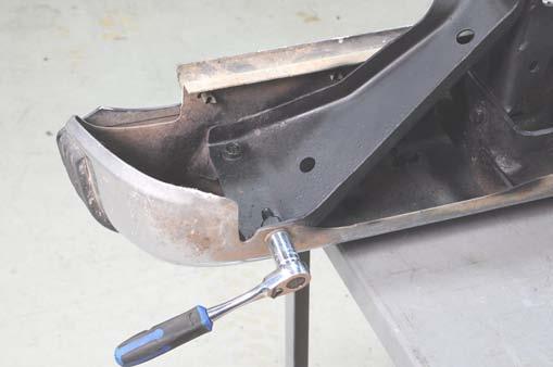 Using a 15mm and 18mm socket, remove the rear bumper mounting bolts. Retain for reuse. See Photo 11.