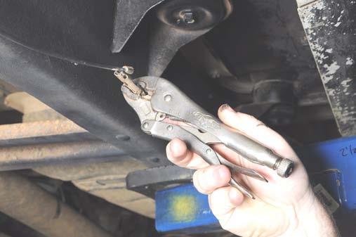 Separate the emergency brake cable at the clip joining the front and rear cables