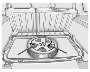 5. 4. Place the tyre, lying flat, in the rear storage compartment. 5. Attach the strap to the cargo tie-down in the rear of the vehicle. 6. Route the strap through the wheel, as shown. 7.