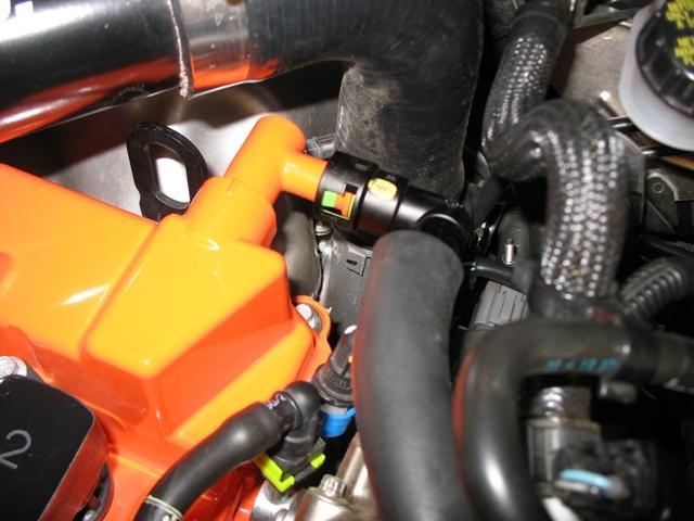 Remove the OEM hose from the CAM cover by squeezing the 2
