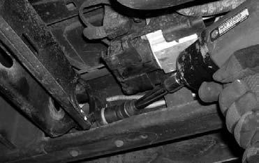 2. Working on the driver side, attach the torsion bar removing tool to the torsion bar cross member, making sure that the unloading bolt in the center of the torsion bar removing tool is in the small
