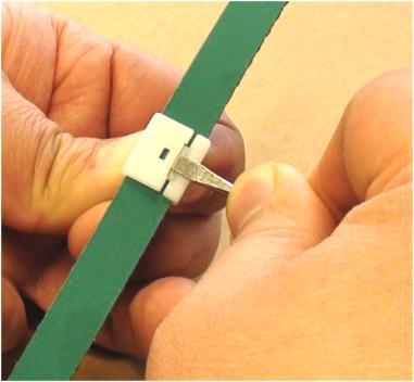 While the belt still stays inside the track, from the Idler end, use the slot