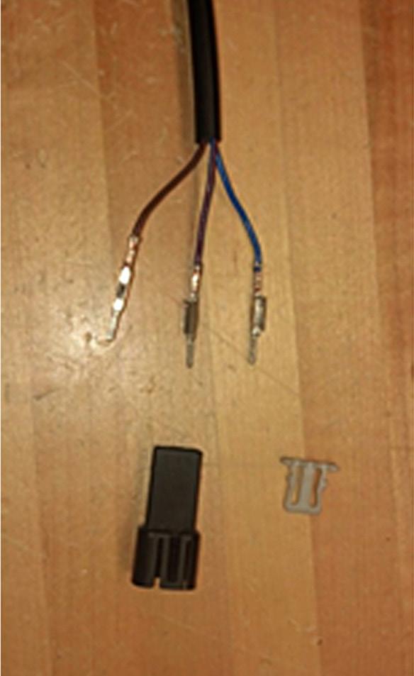 After pulling the wires through, plug the wires into their respective holes in the supplied connector and install the gray clip into the connector. Figure 2.
