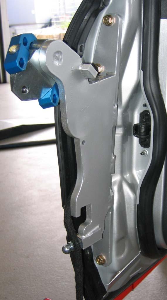 8.) Now the LSD swing arm (Q) has to be installed in the original mounting points on the door with the screws (G).