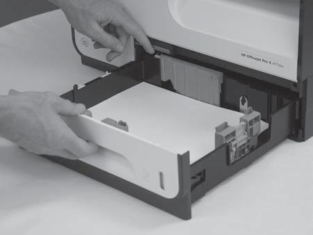 Press the latch in the left-rear corner of the tray, lift the front of the tray up, and then pull the