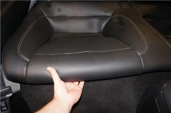 Remove rear seat lower cushion by pressing on 2 plastic latches under front of seat.