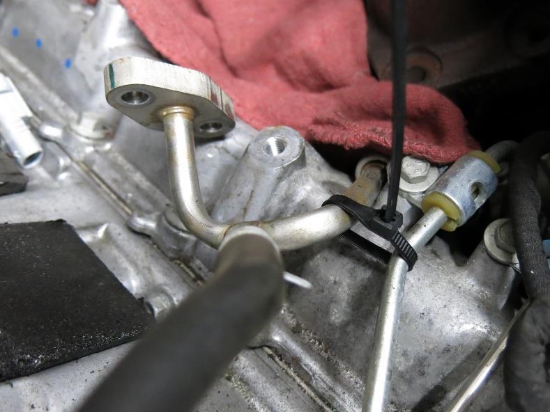 35. Now on the passenger side of the turbo, remove the four bolts that hold the coolant feed and return hardlines to the center section. These gaskets can be discarded.