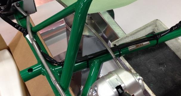 Pass the main cable to the side of the seat and secure it to the frame using the plastic