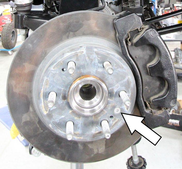 Remove the brake calipers by removing the 2 bolts fastening the caliper to the spindle; it is easiest to hang the caliper from the frame with a short bungee cord or something of the like.