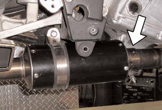 30)Place the supplied Muffler Mount Spacer between the muffler strap tabs and the upper threaded hole on the motorcycle frame.