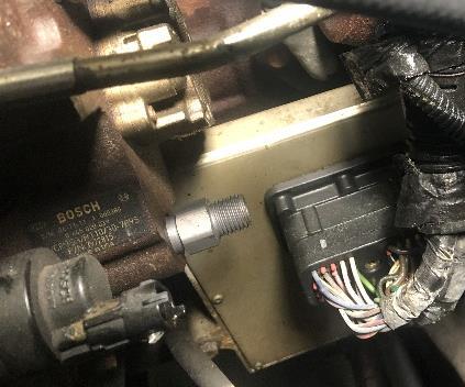 The plug will be to the left of the solenoid looking from above. Carefully remove the plug and spring assembly from the pump housing.