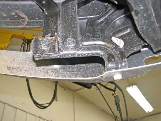 Using a T40 Torx, remove one bolt on the edge of the bumper bracket (grey arrow).