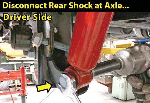 Use a 18mm wrench and 18mm socket to remove the lower shock hardware. Retain hardware.