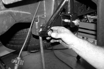 Push the bottom of the coil spring onto the new spacer and raise the floor jack under the axle to hold the coil spring in position. Remove the coil spring compressors.