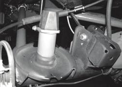 Using a die grinder with a cut off wheel, cut the section from the backside of the coil perch as shown in the photo below. This will allow for additional room for the shock to travel. SEE PHOTO BELOW.