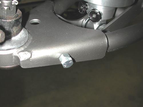 7. Screw a 3/8 x 1 ¼ bolt and nut into the hole in the side of the lower arm. This will act as an adjustable steering stop.