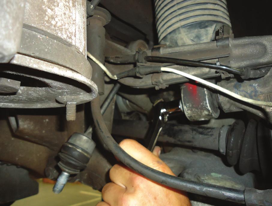 13. LOOSEN AND REMOVE THE LOWER AIR STRUT MOUNTING BOLT. (FIGURE T) FIGURE T 14. LOWER THE AIR STRUT FROM ITS MOUNTING LOCATION AND REMOVE THE AIR LINE.